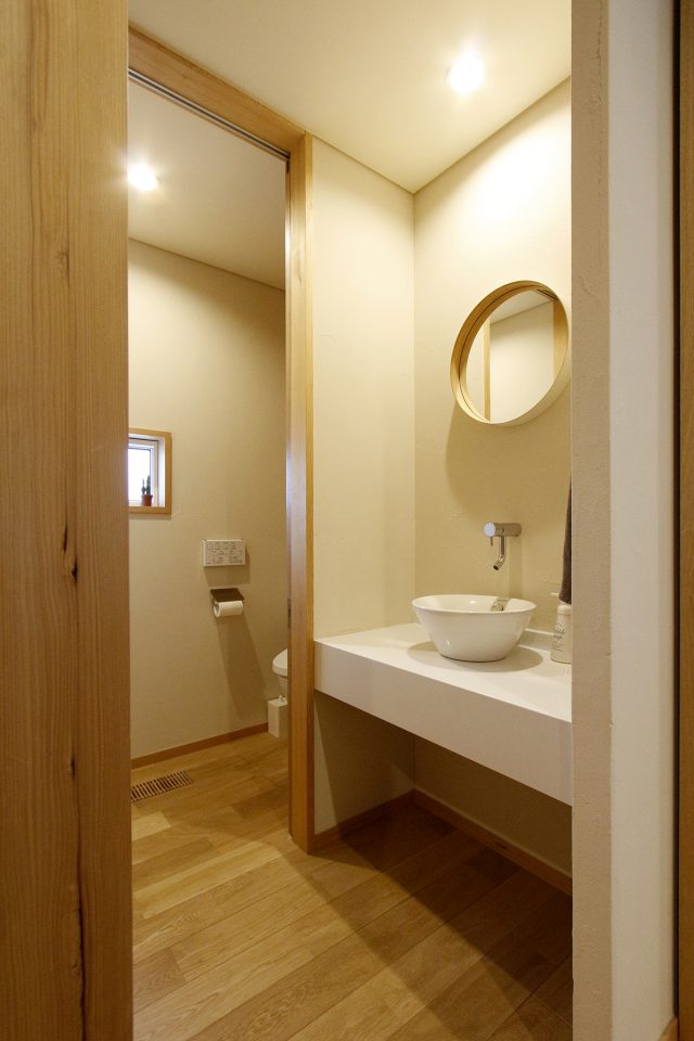 ご夫妻の出身地、岡山で作られた丸い鏡が映える洗面スペース
