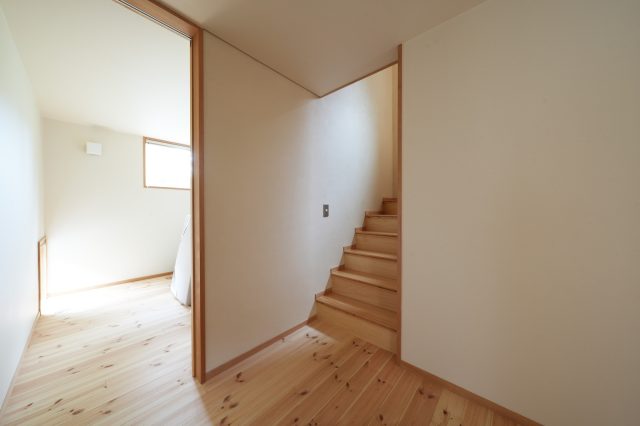 清潔感のある和紙の白い壁が特徴の1階。奥は寝室。