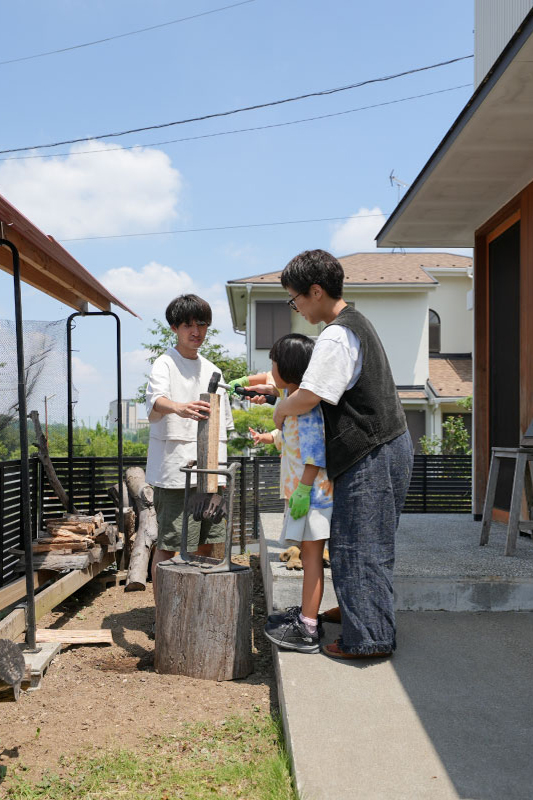 DIY薪棚の前で家族そろって作業。薪割りも大切な家族時間に 