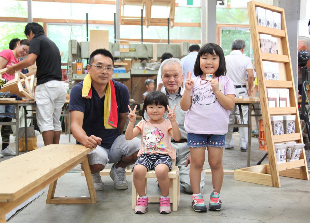 完成した椅子に座って、大工さんと一緒に。フェスタは家を建ててくれた大工さんにまた会える機会でもあります