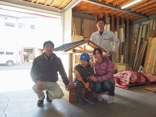 ミニ上棟を終えて、完成した小さな家をかこんで記念撮影。中心がこうすけくんとお母様。向かって左が当日の体験の段取りをしてくれた橋詰監督。右が棟梁の山本大工さん。