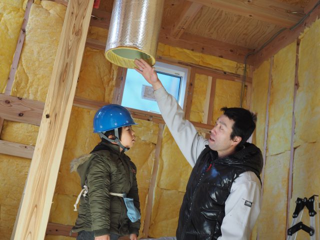 「屋根で集めた太陽の熱を、大きな扇風機で床下に送っているんだよ。ほら、あったかいだろう」と高橋棟梁。