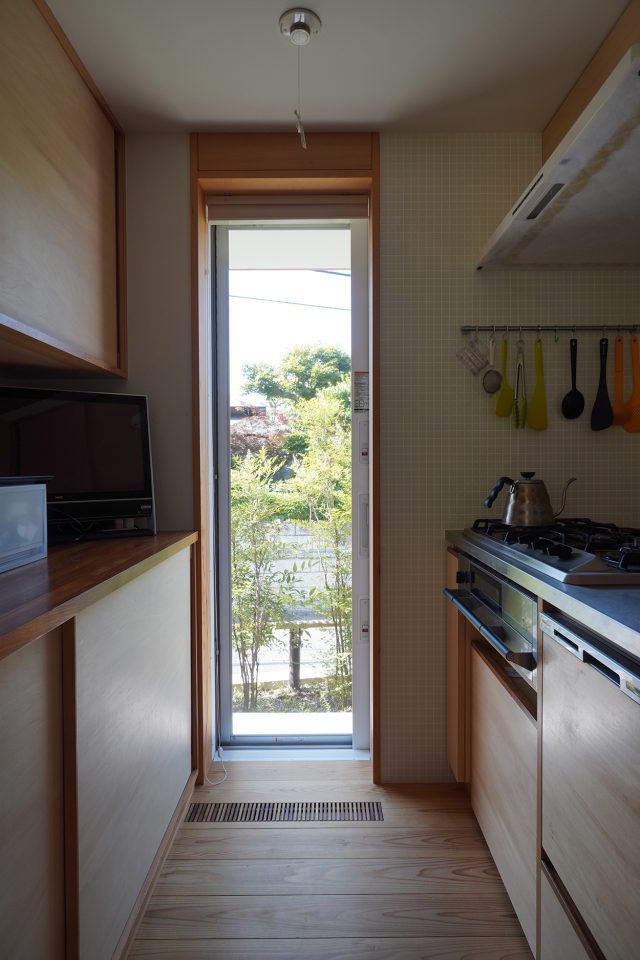 勝手口より。お向かいのお庭とナンテンが重なり、奥行きのある景色に。