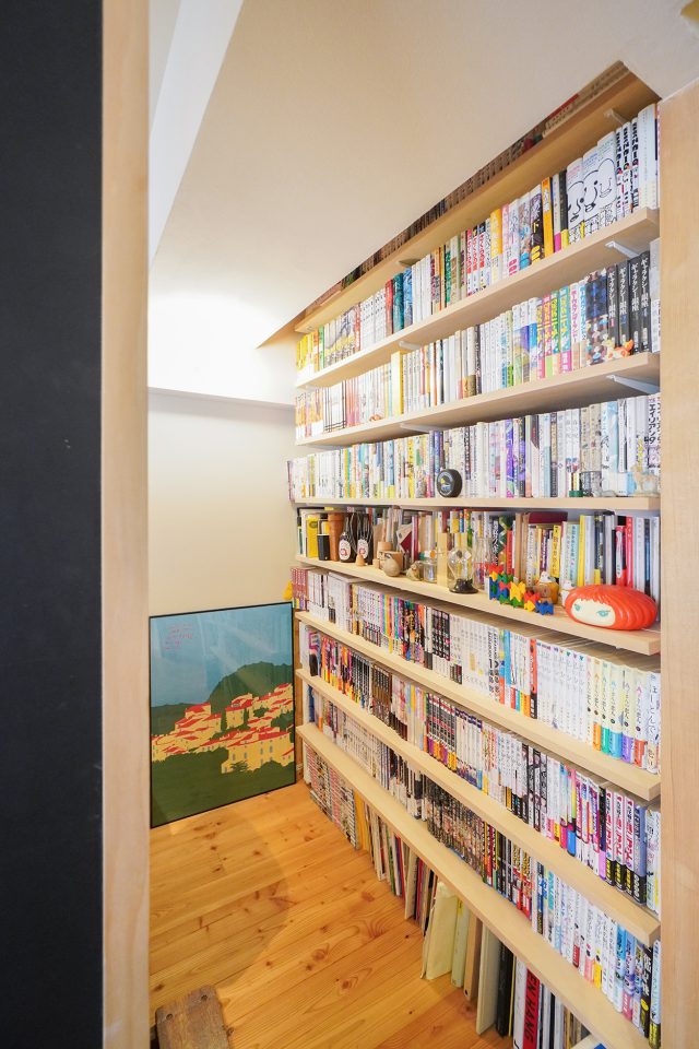 背後の本棚には、仕事や趣味の本がびっしり。