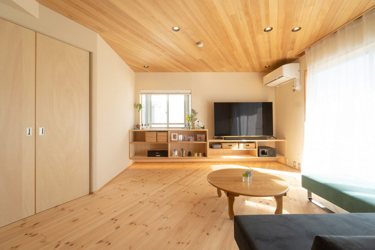 天井と床を斜めに貼ったリビング。出窓と合わせて造り付けたテレビボードもポイント。