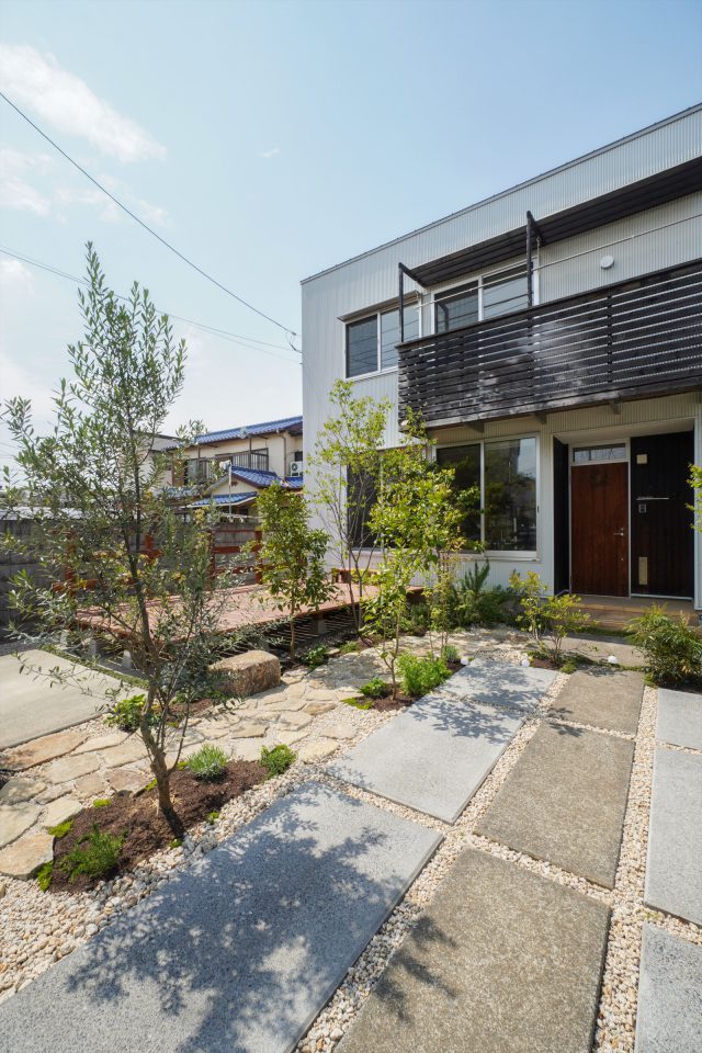 駐車スペースからの眺め。大工の益子友三さんが窓に合わせて斜めにカットしたウッドデッキが庭に奥行きを生んでいます。