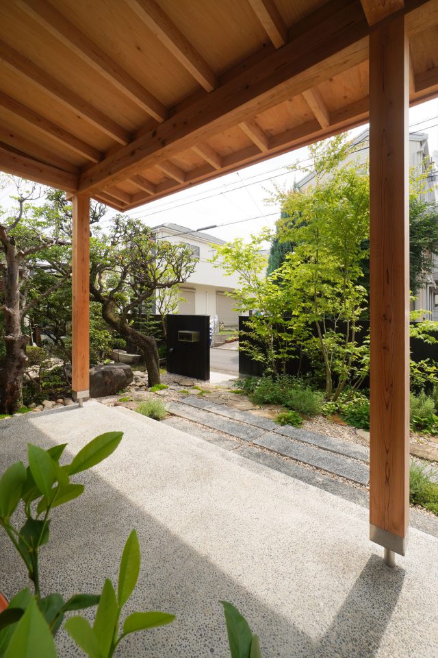 玄関前には、ラベンダーなどのハーブ類やブルーベリーなどを植栽。向かいのお宅の植栽も借景に。