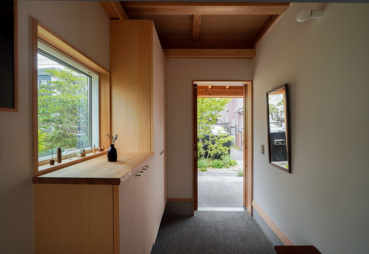 窓から庭先の緑が見え、爽やかな玄関。