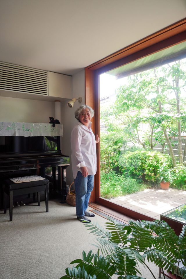 窓辺に佇む佑子さん。窓を開けると心地よい風が抜けます。