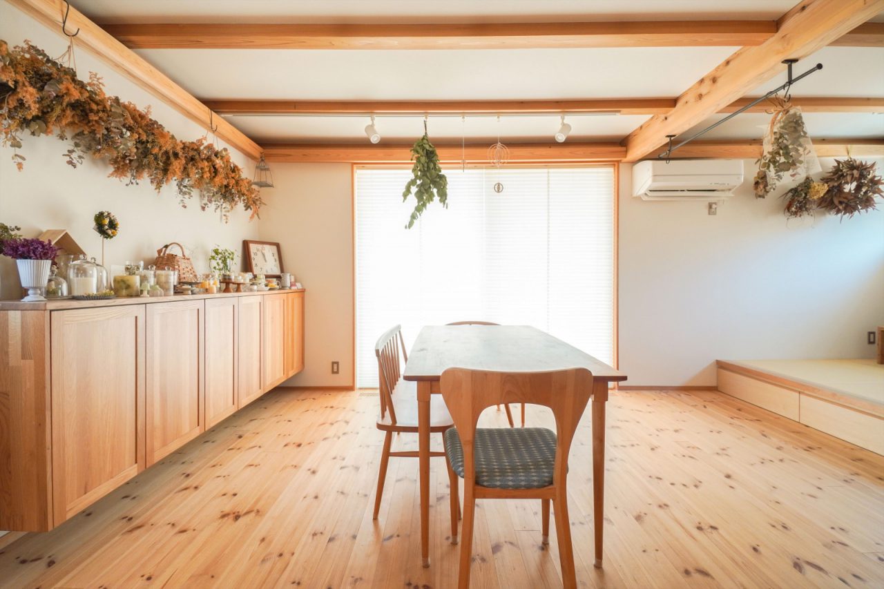 キッチンから見たリビングダイニング。 軽やかな印象にするために、造り付けの棚は足元を浮かせる造りに。棚の上や梁に奥様の作品が飾られています。