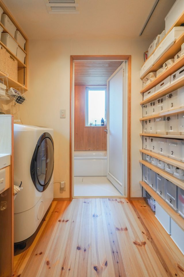 洋服やタオルがきちっと整理された洗面脱衣室。棚板は収納に合わせて増やしました。