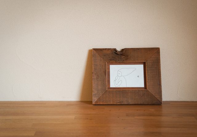 デスクスペースにもさりげないアートが。ミナ・ペルホネンのポストカードを素敵な額に入れて。