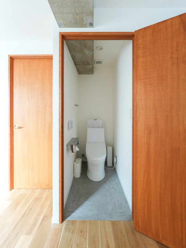 現しの梁が貫くW.C.。モールテックスの床は、お手入れも楽で水回りに最適。