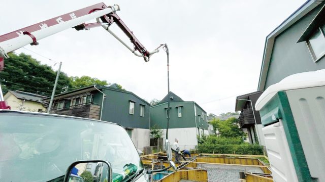 クレーンの先のホースから流し込まれるコンクリート