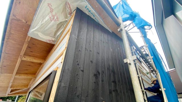 大工の谷口さんと上小園さんによる、焼杉板張りの様子。