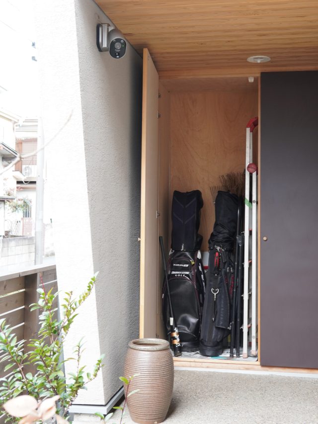 アプローチスロープの突き当たりの玄関ポーチに掃除道具やゴルフ用品などを収納する外物置を設けたことで、玄関はすっきり。