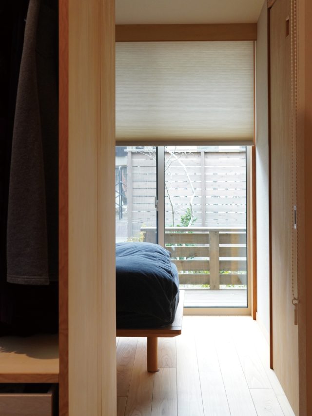 ご夫婦の寝室の間は家具とロールスクリーンで間仕切る。