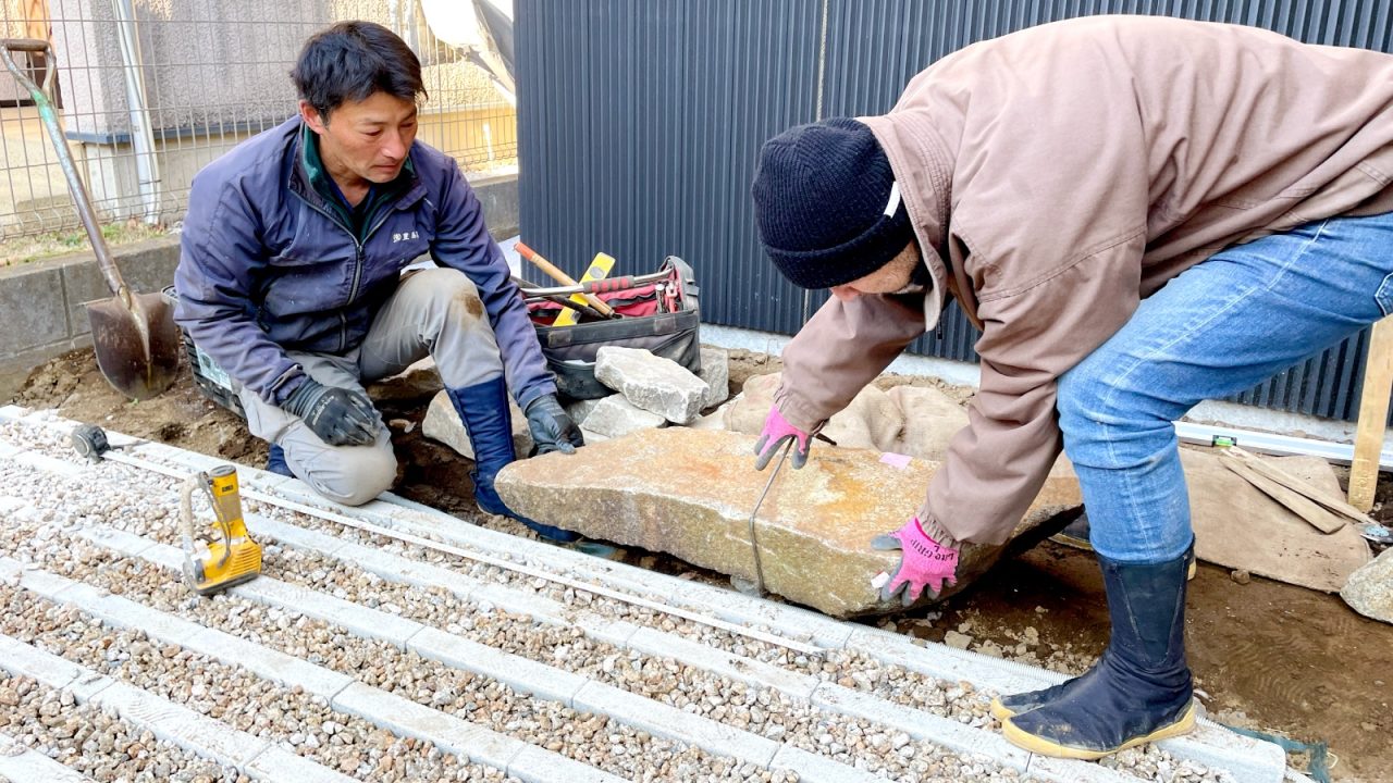 車止め用の美富石を配置している様子。100キロ近い石をクレーンで吊りながら場所や角度を確認します。