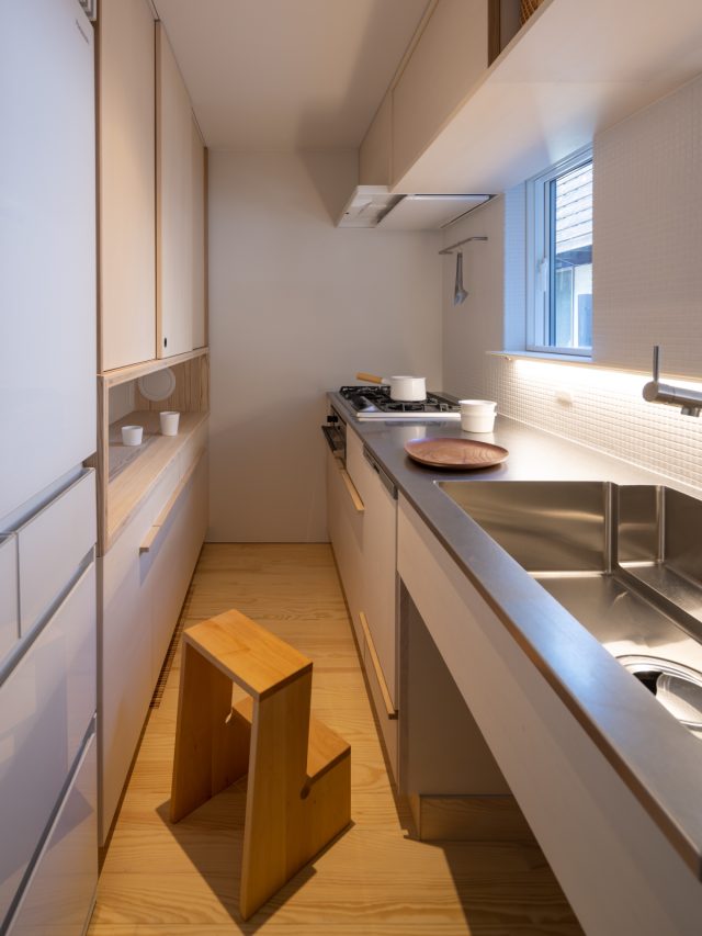 ウッドデッキやリビングにいる家族の様子がわかるキッチン。