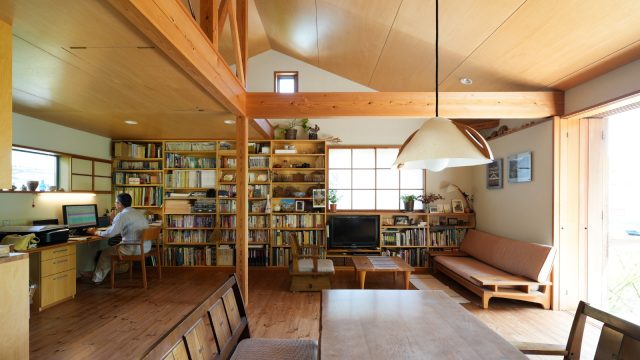 壁一面の大きな本棚にはブータンの書籍や民藝、植物の本などがぎっしり。絵になる風景です。ワークスペース、リビング、どちらからも本が近く、読書が身近になるのがいいですね。