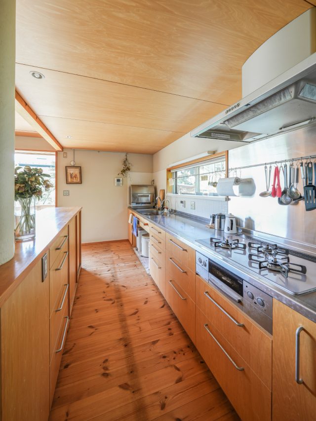 二人並んでもゆとりがあるキッチン。緑を眺められるように設けた窓の枠内にもパイプを渡し、ふきんを干したり、よく使うものを吊るしています。