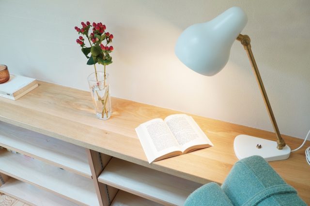 Louis PoulsenのVL38テーブルランプは白い塗り壁の空間とマッチ。真鍮のアームの異素材感がアクセントに。柔らかな光が読書にぴったり。