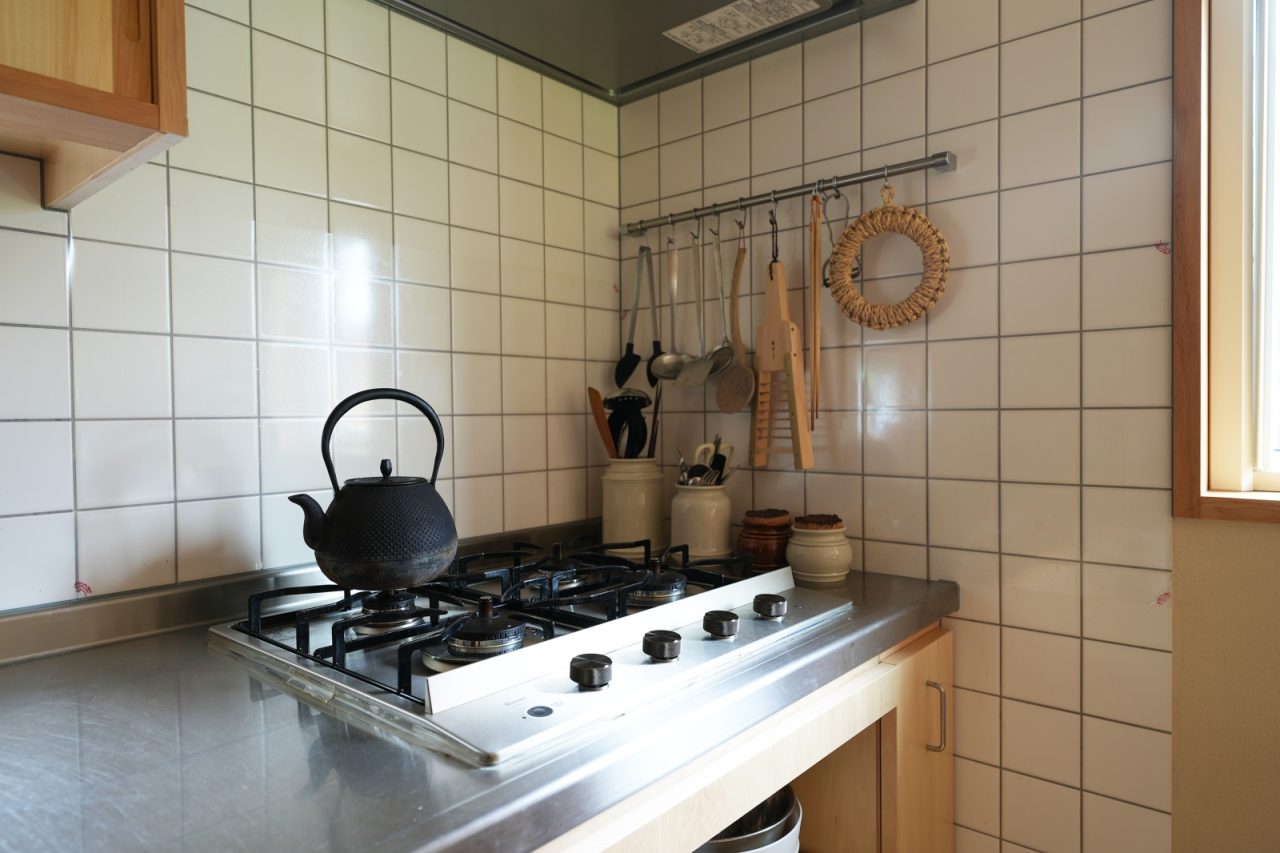 必要な道具をパッと手に取ることができる吊るす収納とタイルが特徴的なキッチン。