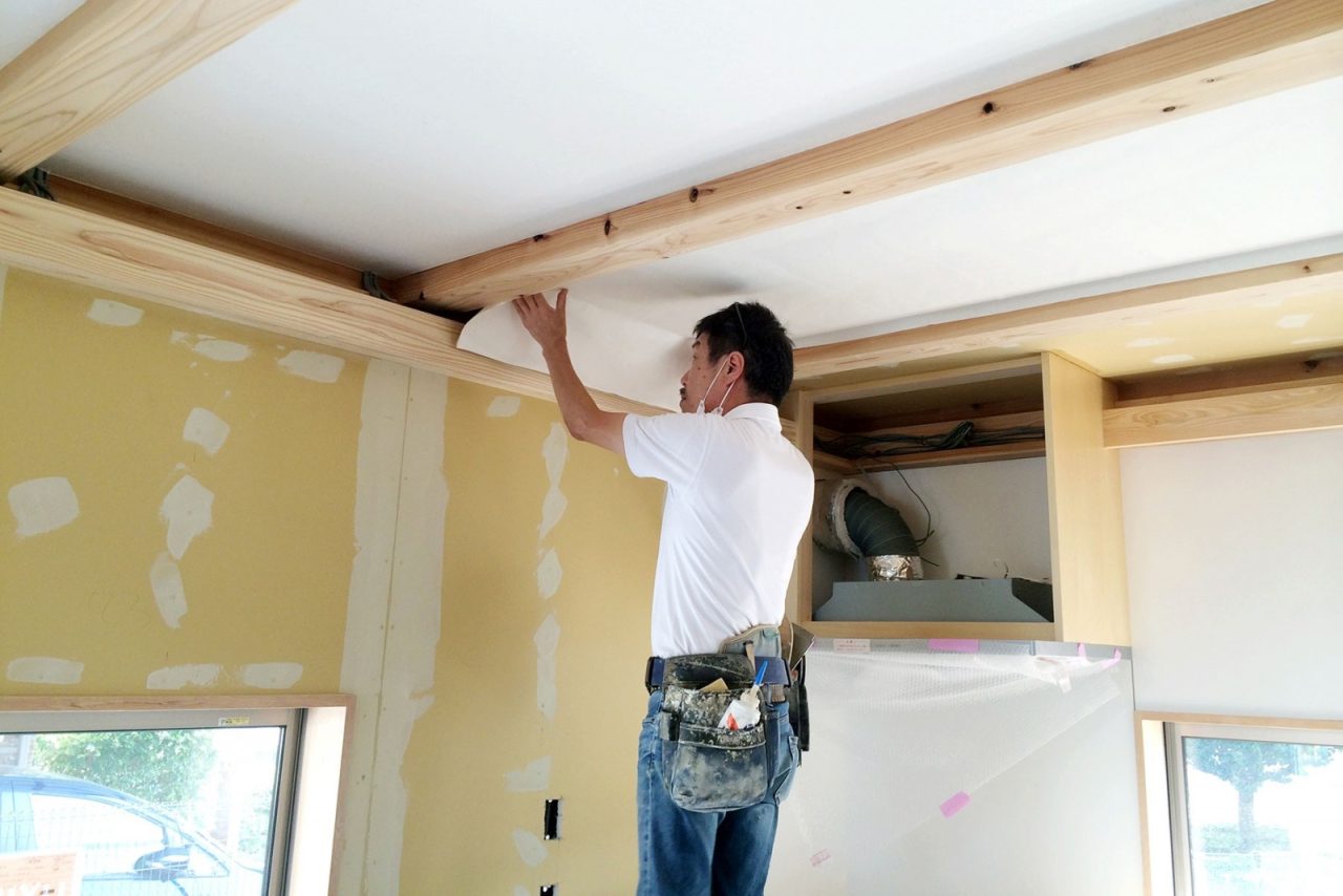 天井に和紙を貼る加藤さん
