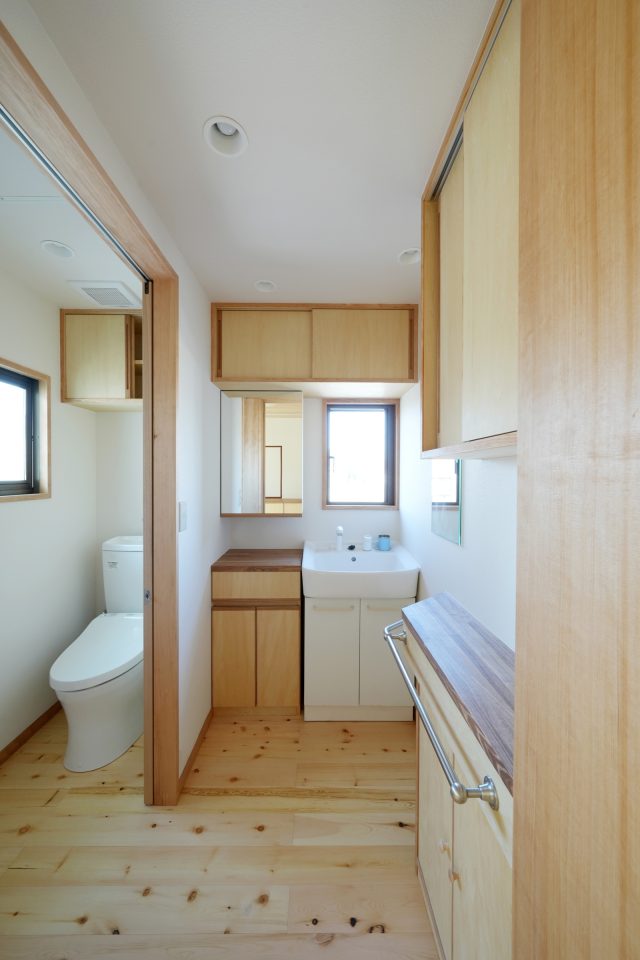 洗面台は既存を活かし、その周りに職人さんの手仕事による木の造作収納をつくりました。