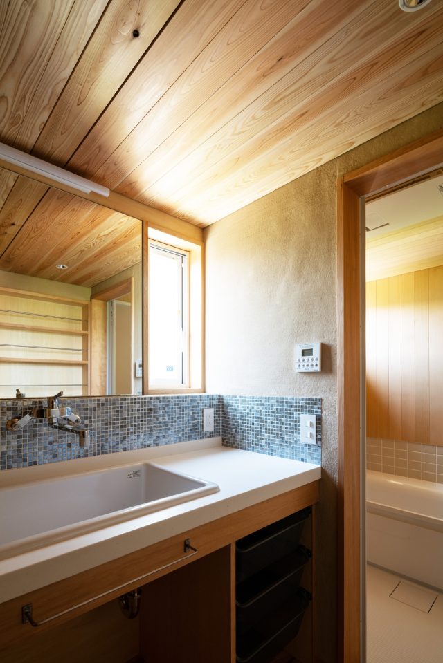 薩摩中霧島の左官壁、タイル、ヒバ板張りと仕上げを分けた洗面脱衣室。さながらホテルのような高級感を感じる空間です