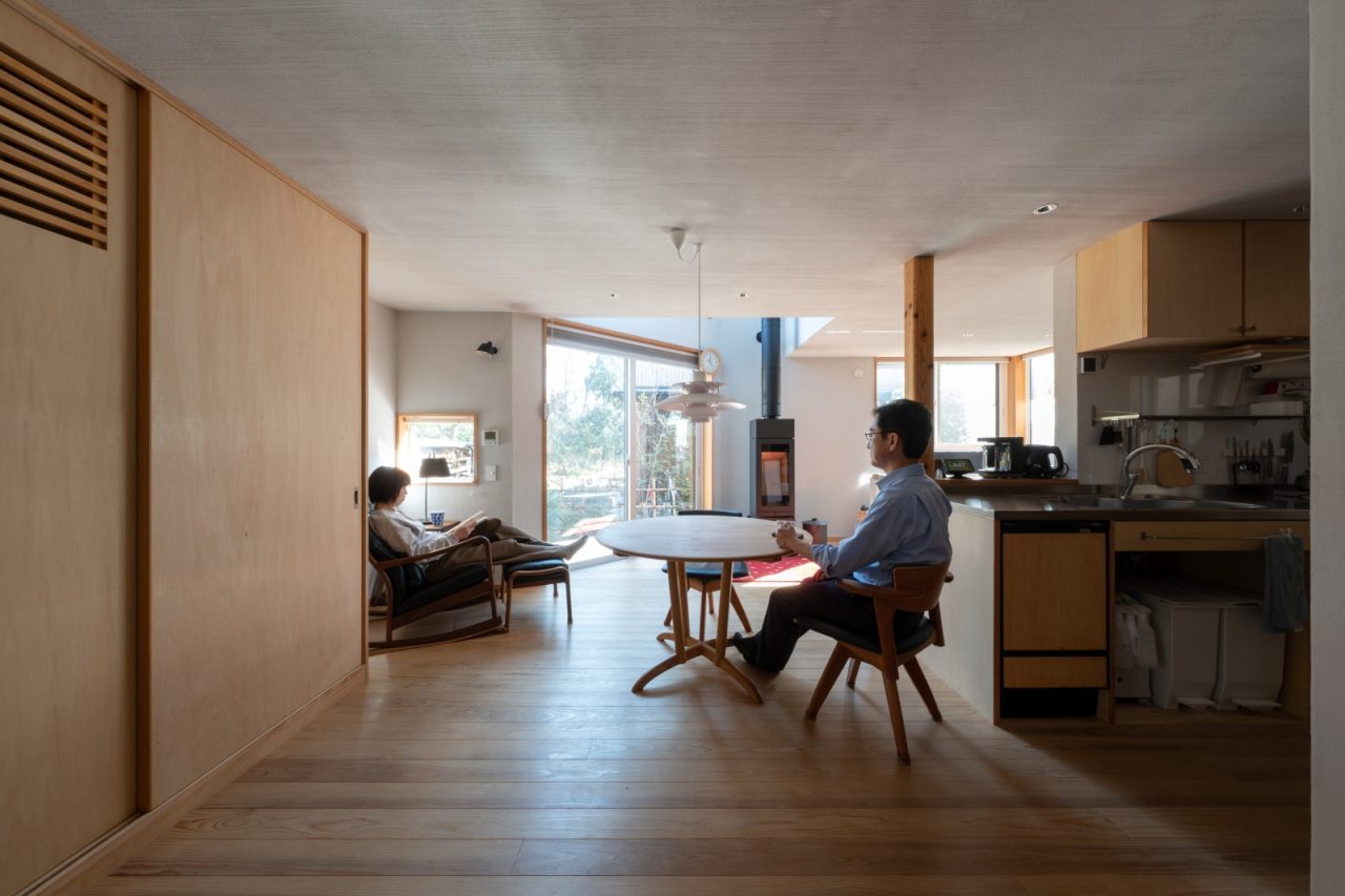 吹抜けの光、景色が主役のLDK。中央の丸テーブルは元々使っていた一枚板テーブルをリメイクしたもの