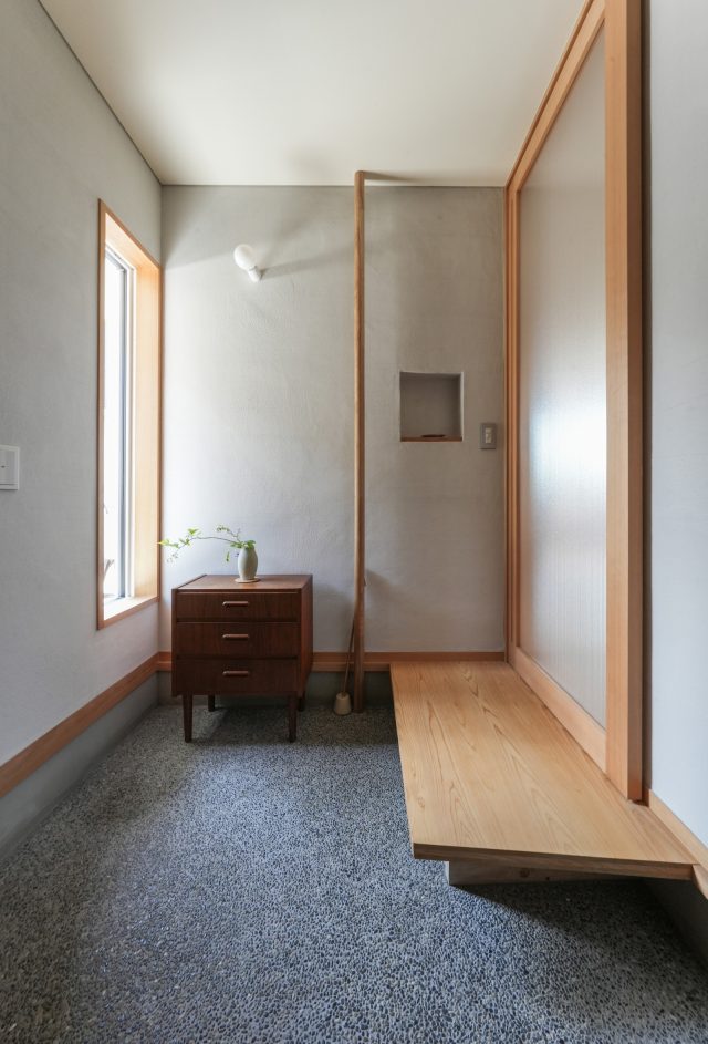 広々とした玄関。土間は洗い出し、壁はグレーの薩摩中霧島壁