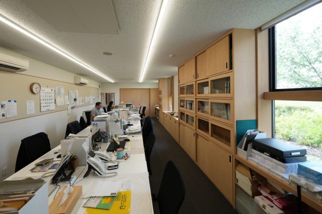 窓からは子どもたちが暮らす家や庭の木々が望める事務室