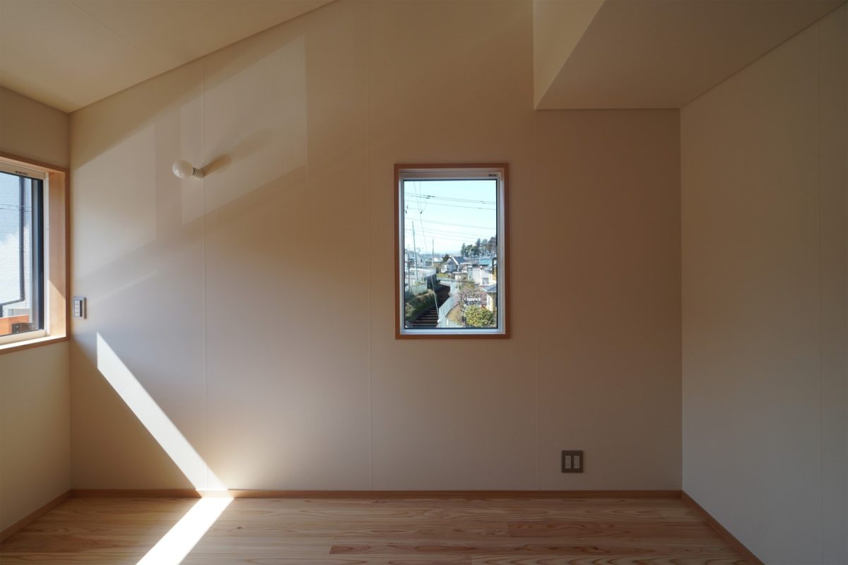 斜めの天井と額縁のような窓が印象的な居室