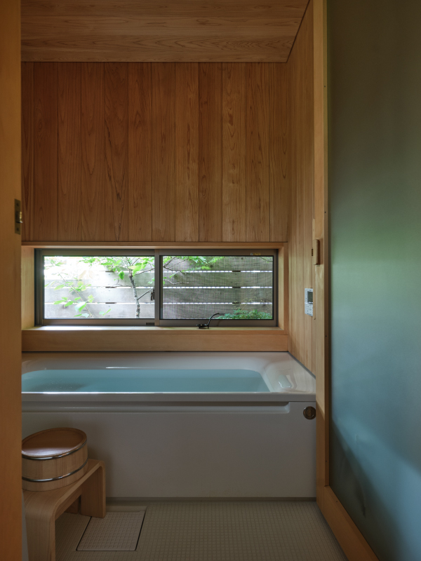 壁・天井のサワラが香る浴室。窓を開け坪庭を眺めていると、露天風呂に入っているよう。