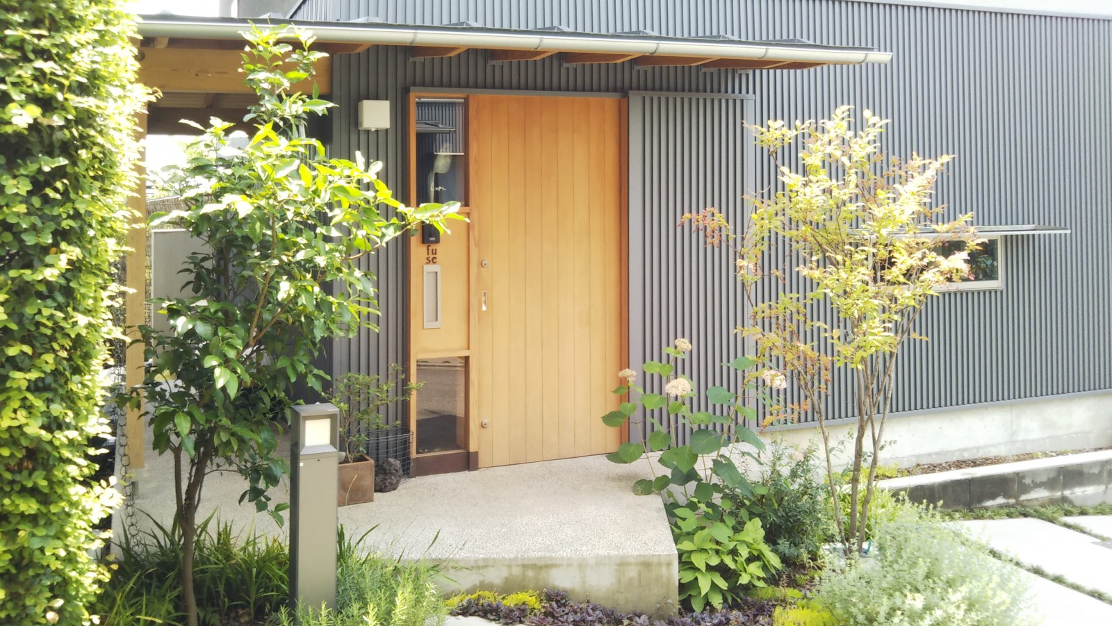 玄関アプローチの樹々も成長し、暮らしとともに馴染んできました