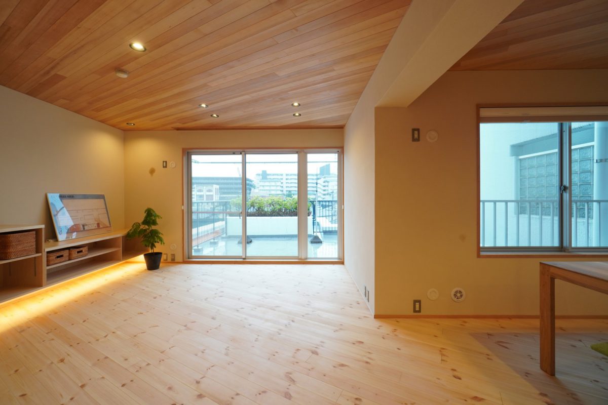 床と天井は斜め方向の板張り仕上げに。テレビボードや収納の下に間接照明を入れて浮遊感を演出