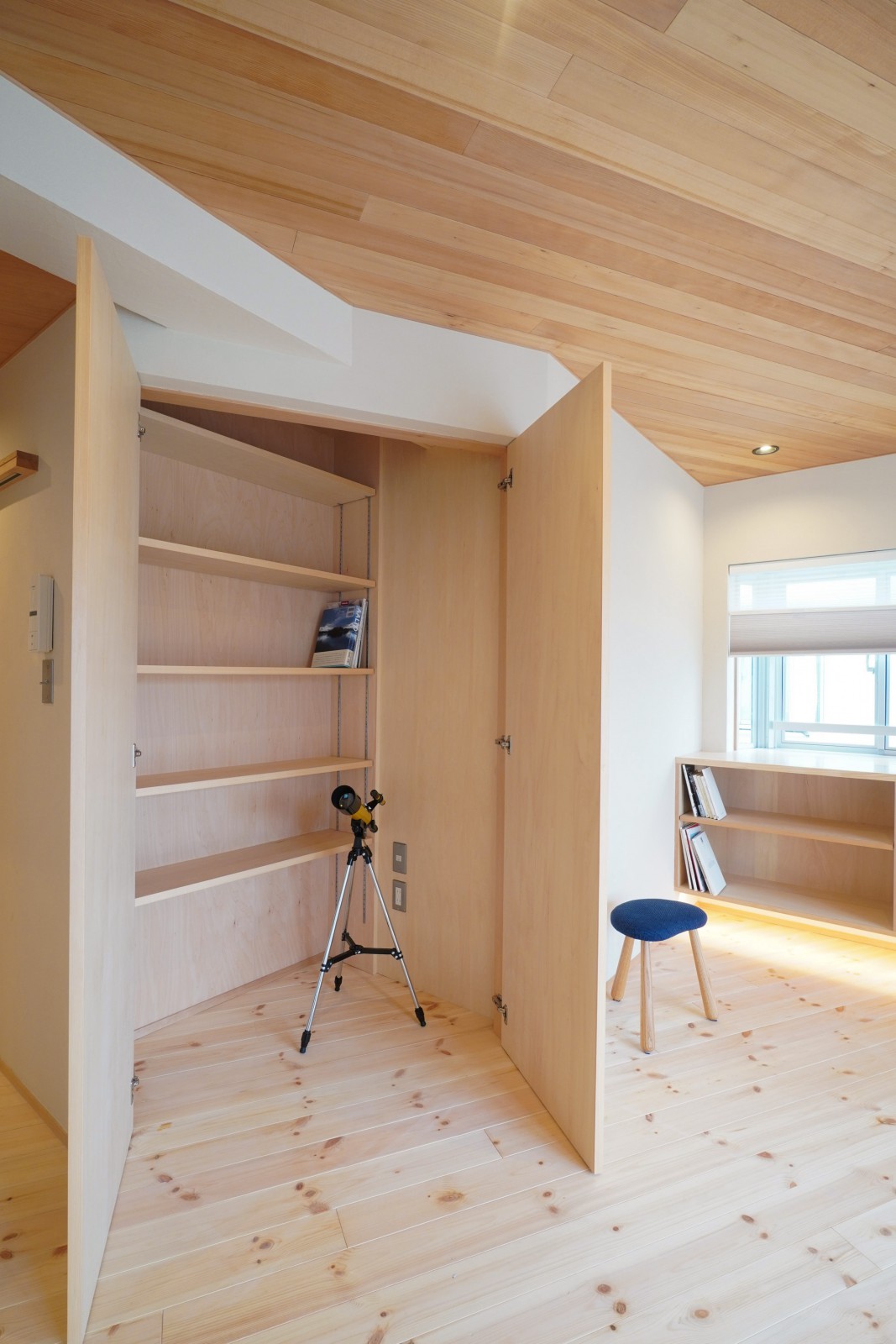 収納扉を開くと棚の手前にスペースがあり、掃除機などを充電しながら収納できる