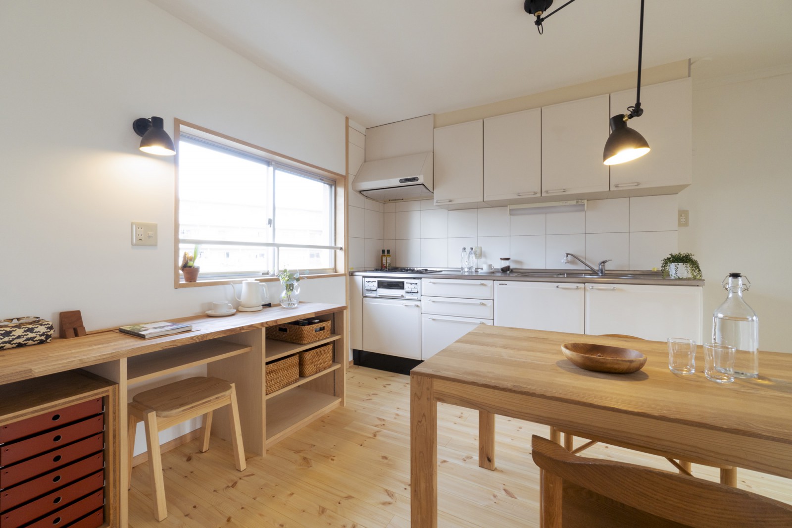 お子さんが勉強したり、在宅時のひと仕事もできるカウンター兼家電収納を造作。壁面の収納はLDの照明と同じシリーズのブラケットで統一感を。