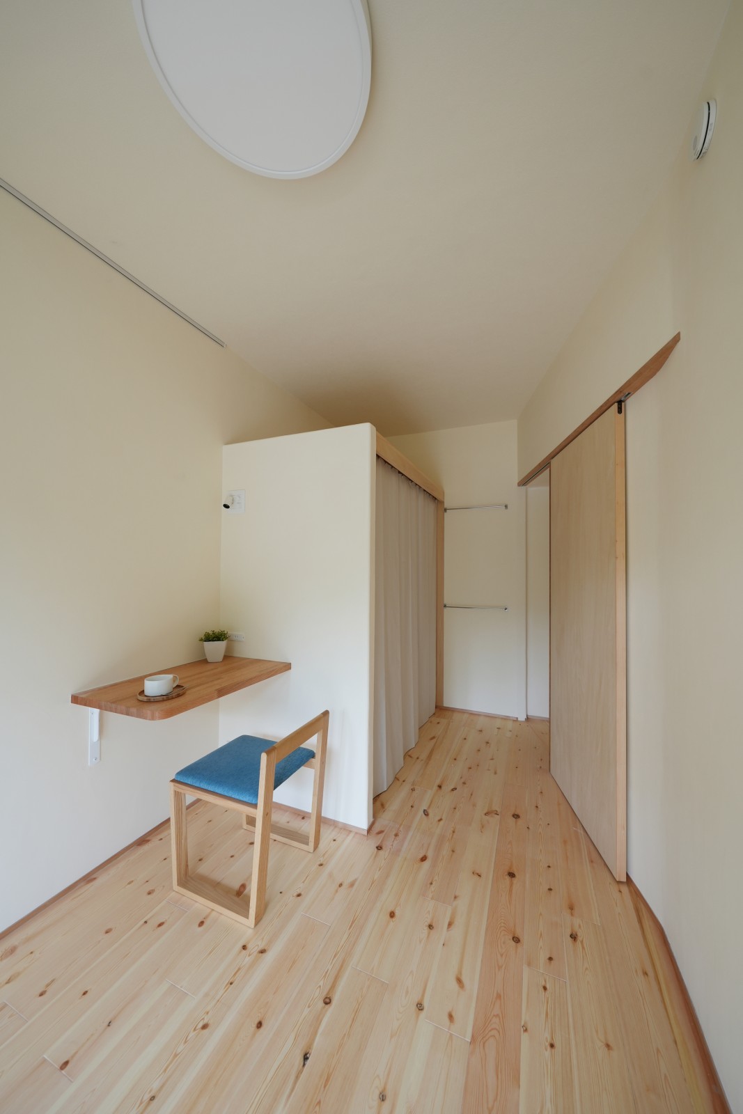 カーテン収納とコンパクトな作業机のある居室