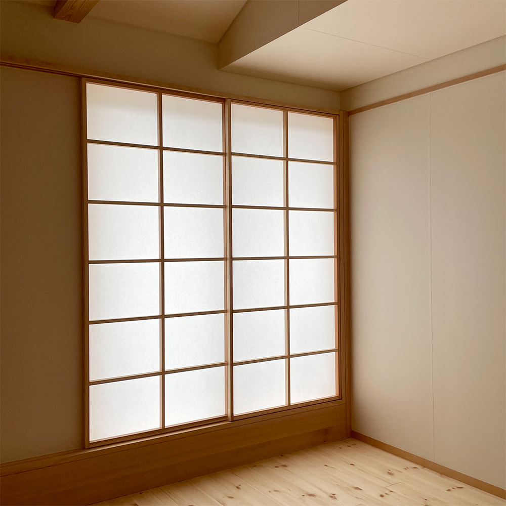 4畳半の個室 大きな窓からバルコニーへ。小屋裏へ抜ける階段も設けています。月桃紙の壁が温かい雰囲気を演出しています。