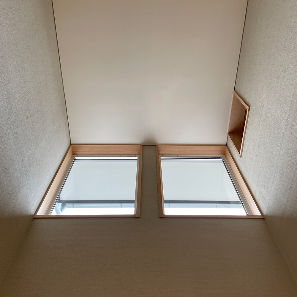 ビングの吹き抜け 窓から注ぐ陽の光も、薩摩中霧島壁に反射して柔らかく届きます。