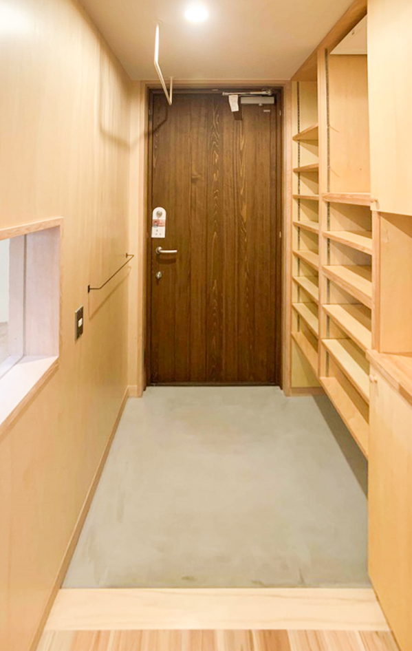 玄関床はモルタル仕上げ。 キッチンとの間に小窓を設けて、気配が感じられるようにしています。