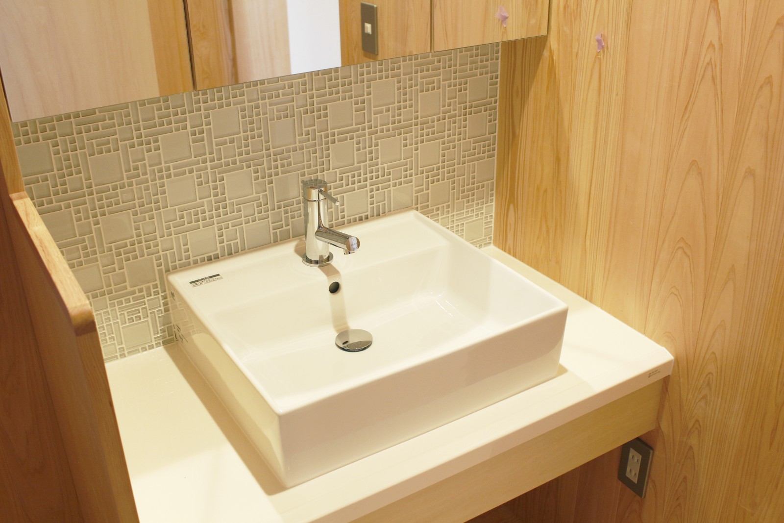 ガラスタイルが印象的なコンパクトな洗面。