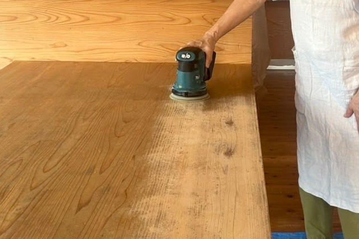 電動サンダーでテーブルを磨きます。