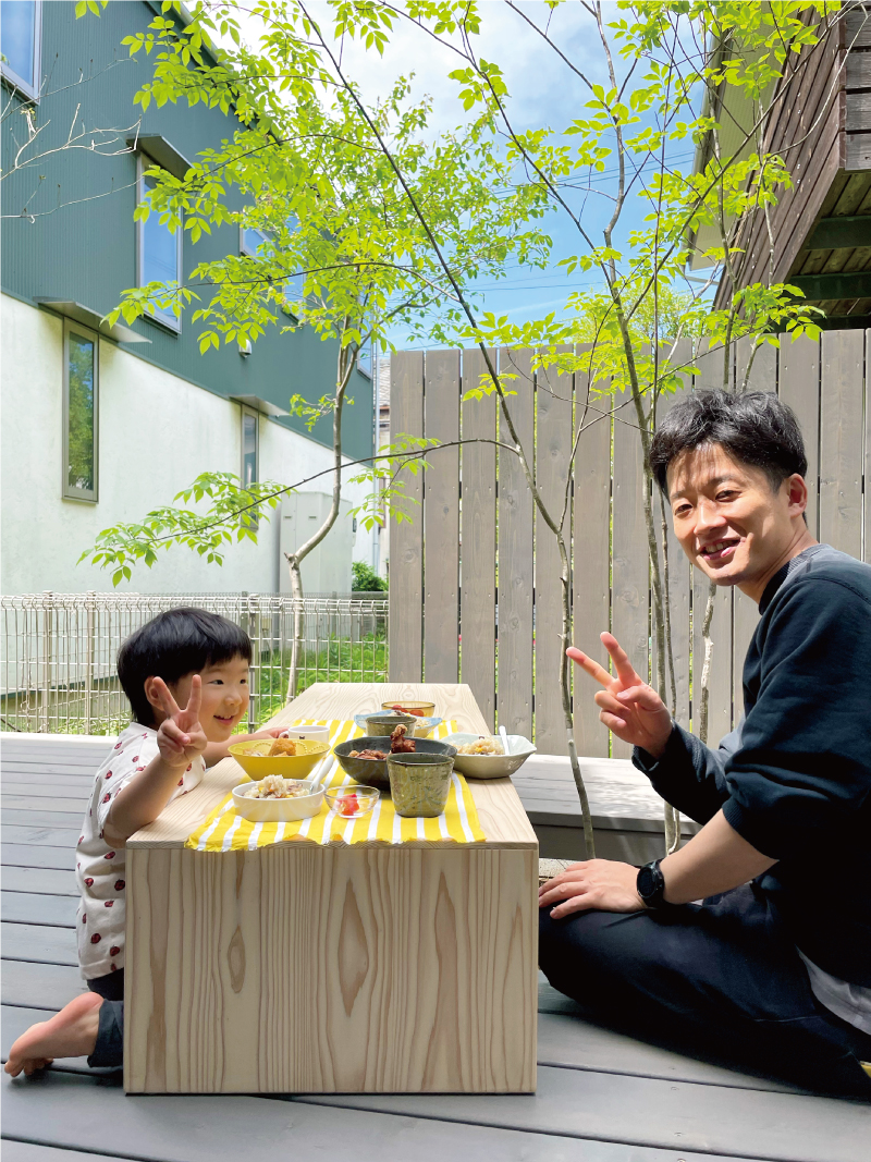 ウッドデッキにテーブルを置いて楽しむ「デッキランチ」。家にいながらアウトドア気分を味わえる豊かな居場所です。