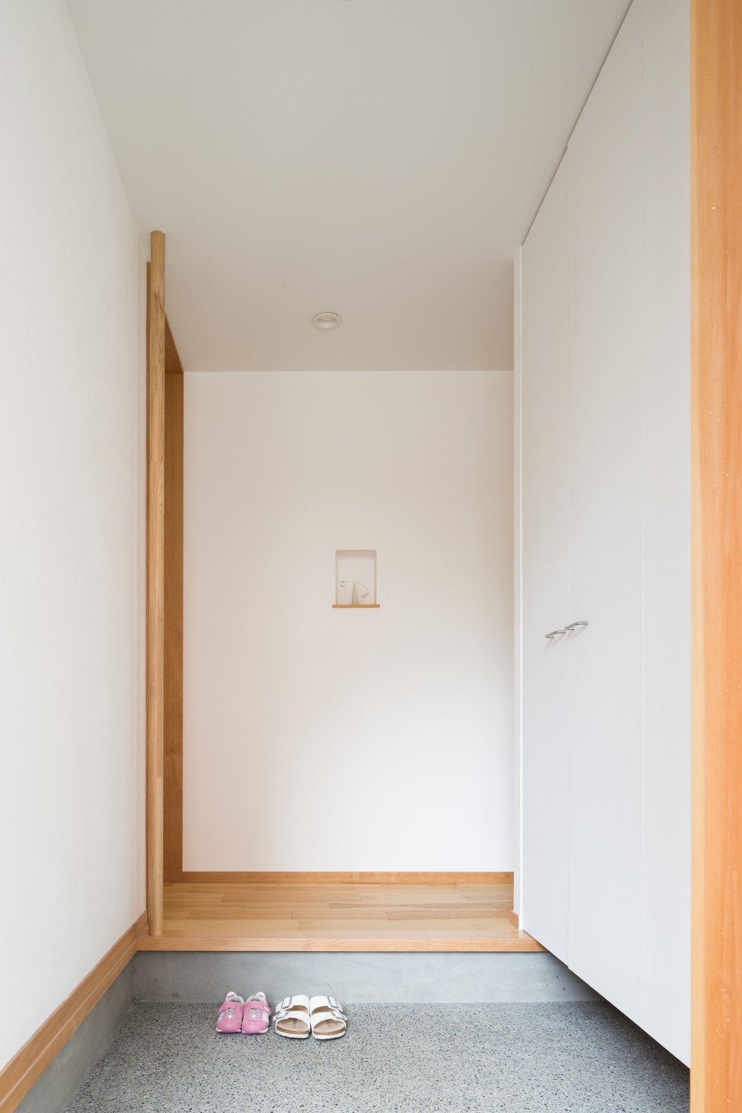 大人が2、3人入れるくらいゆったりとした広さの玄関。正面のニッチにはお気に入りの作品を飾っています。