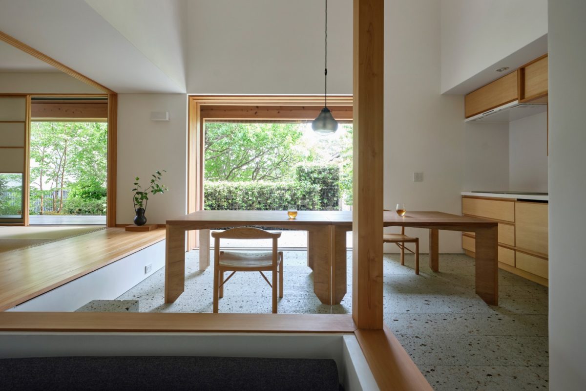 建物の南北に大谷石の土間が通り抜ける「通庭」。特注の木製建具を壁に引込めば、内と外と一体になり、食事をしながら緑や風や鳥を楽しめます。ご近所さんが集まるので、台所は壁付けにしてコンパクトに、手前に食品庫を設けスッキリと使えます。