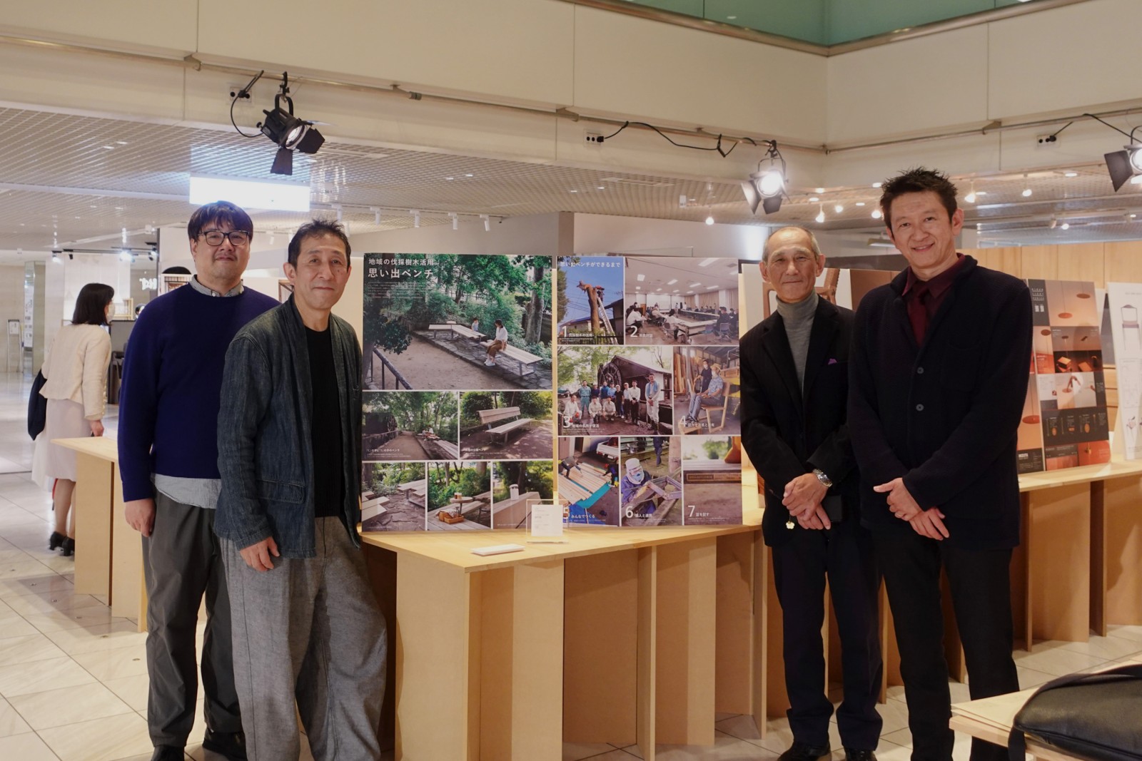 トロフィーと展示中のパネルを囲んで