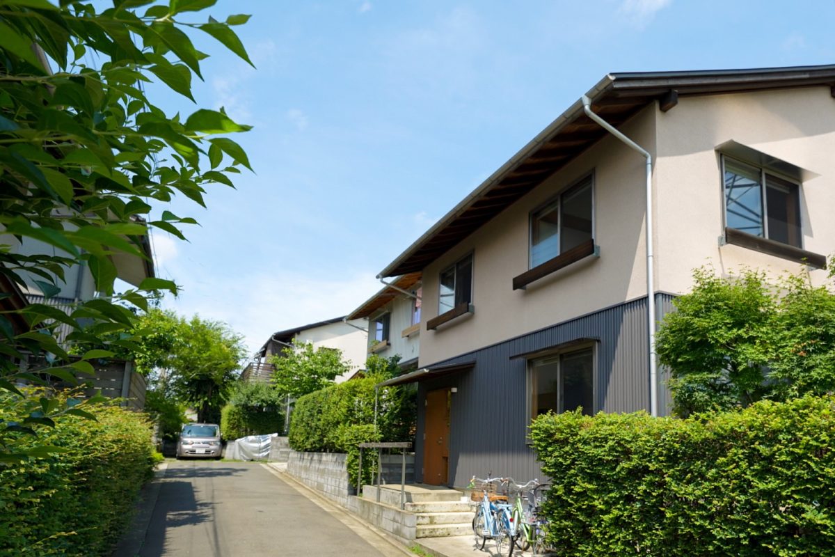 ソーラータウン西所沢には、狭山丘陵を引き込むよう植えられた木々、 子供達の遊び場となっている坂道と駐車場、蔵のような外観で揃えられた二十二軒の家があります。 夕方、夕陽に染まる八国山を借景にした美しい街並みに、駆け回る子供達と井戸端会議をする大人達の姿があり、お寺の鐘が聞こえてきます。